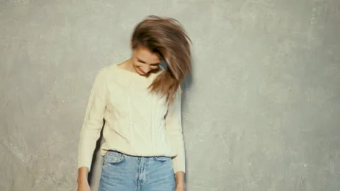 Funny and cheerful model posing near gray wall in studio Stock Footage 146119397