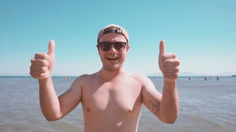 Funny and happy guy is saying "ok" "yes" with his fingers on beach. Stock Footage 112288524