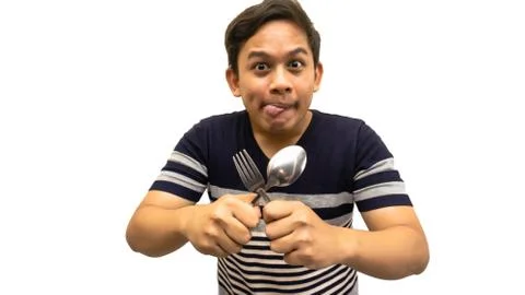 Funny and hungry face expression of young Asian Malay man Foto stock