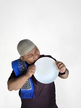 Funny Asian Man Biting Empty Plate Stock Photos