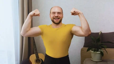 Funny athletic man looks at camera, smiles stupidly and poses, showing muscles 스톡 동영상 243755914