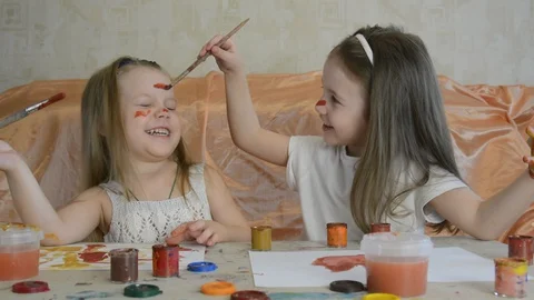 Funny babies paint on their faces. Stock Footage 129936127