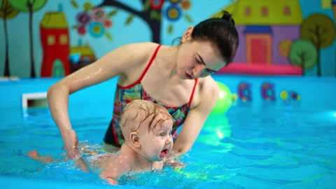 Funny baby boy is crying when coach splashes water on him.  Video stock 261220594