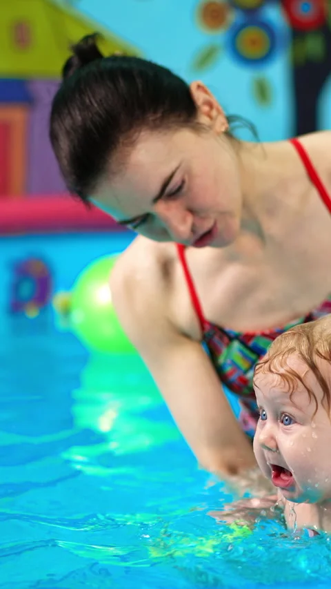 Funny baby boy is crying when coach splashes water on him. Video stock 313517037