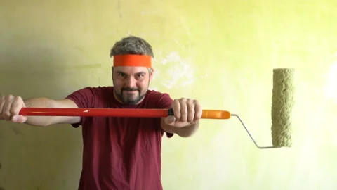 Funny bearded man dancing against a wall with a mop 4K Stock Footage 126124971