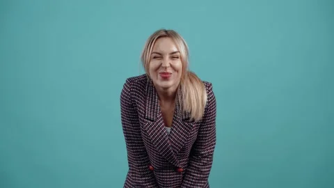 The funny blonde purses her cheeks, forms a fish face, smiles sincerely and is Stock Footage 153974980