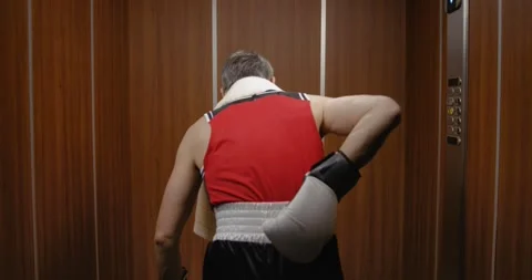Funny boxer taking an elevator after losing a match Stock Footage 308919600
