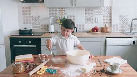 Funny boy is cooking. Boy put a sugar in the bowl. Boy is helping to the parents Stock Footage 132242535