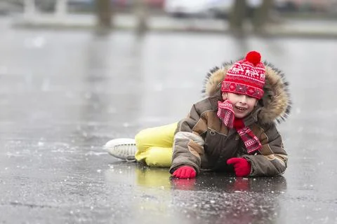 Funny boy fell down while skating. Stock Photos