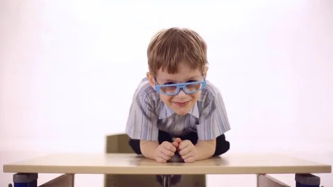 Funny boy with glasses sitting at school desk Stock Footage 72269101