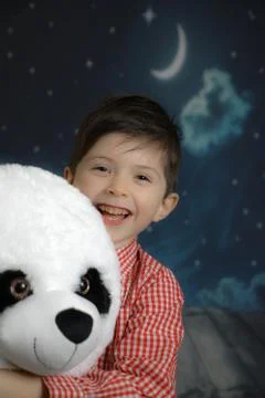 Funny boy hugging a teddy bear in front of the moon Stock Photos
