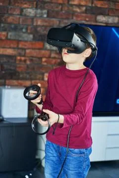 Funny boy in a maroon jacket playing virtual reality Stock Photos
