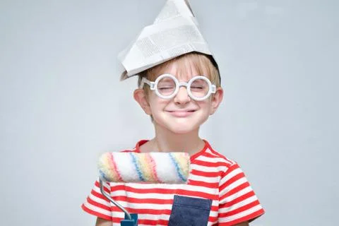 Funny boy in a paper hat with a roller in his hands. Portrait Stock Photos