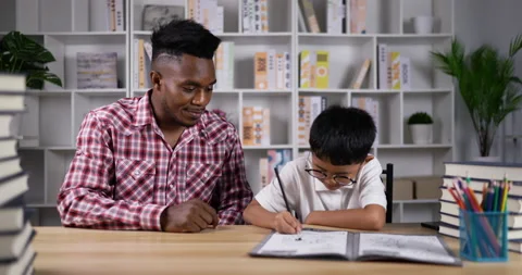 Funny boy playing game on smartphone after young african talking with mobile  Видео 200813402