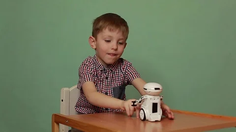 Funny boy playing with an interactive toy robot that actively rejoices. Stock Footage 125183557
