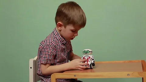 Funny boy playing with an interactive toy robot that actively rejoices. Stock Footage 125183651