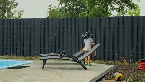 Funny boy put a bag on his head to shelter from the rain Stock Footage 168495098