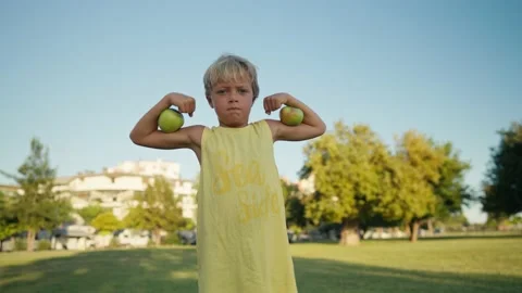 Funny boy with red apples shows biceps. 스톡 동영상 205850035