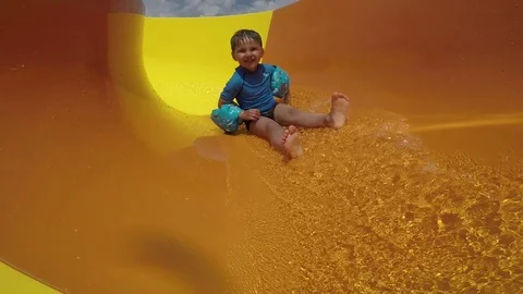 Funny boy roll with yellow water slides Stock Footage 75411926