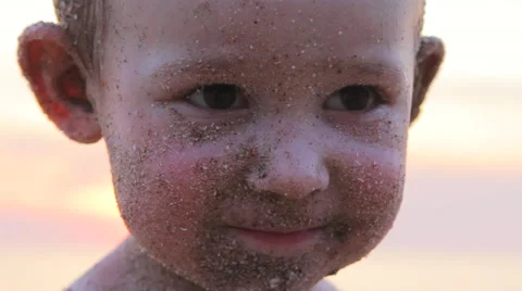 Funny boy with sand on his face Stock Footage 64210878