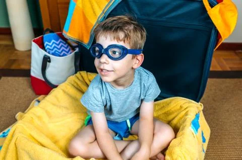 Funny boy smiling sitting inside a suitcase Stock-Fotos