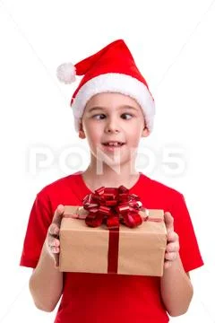 Funny boy, squint eyes, santa hat on his head, with the gift box in the hands Stock Photos
