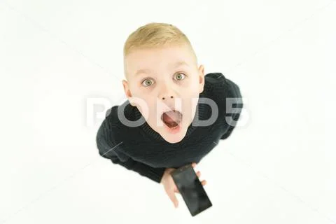 The funny boy stand with a smartphone. View from above Stock Photos