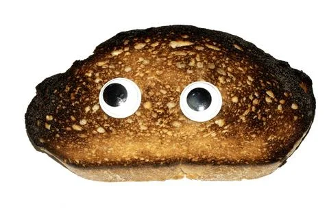 A Funny Burnt Toast Bread Slice Roll With Googly Wobble Eyes Stock Photos