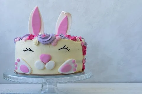 Funny cake in the shape of a bunny head with ears. Postcard for Easter and bi Stock Photos