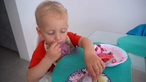 Funny caucasian boy eating beetroot soup straight from plate Stock Footage 123759038