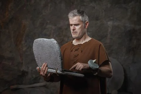 Funny Caveman Working on a Primitive Stone Laptop - Prehistoric Digital Tec.. Stock Photos