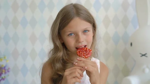 Funny child with candy lollipop, happy little girl eating lollipop, kid eat Stock Footage 93825718