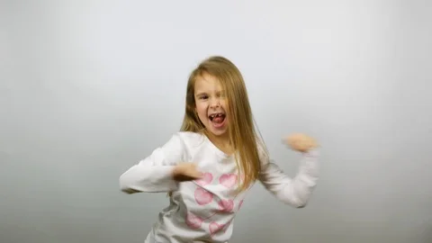 Funny child dancing. Young amusing girl rejoicing victory Stock Footage 86290738