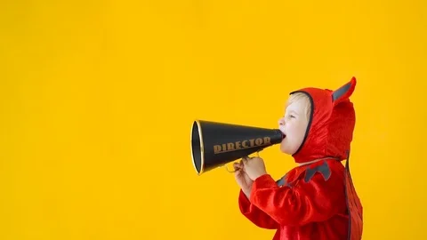 Funny child dressed devil costume speak by megaphone Stock Footage 115601910