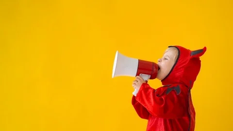 Funny child dressed devil costume speak by megaphone Stock Footage 115601980