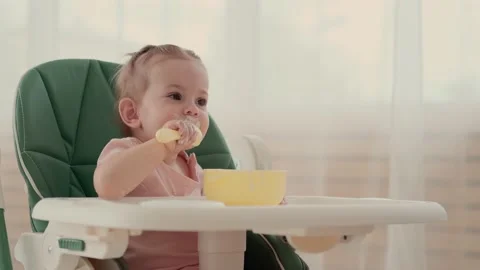 Funny Child eats and laughs while sitting at a table at home Stock Footage 156472635