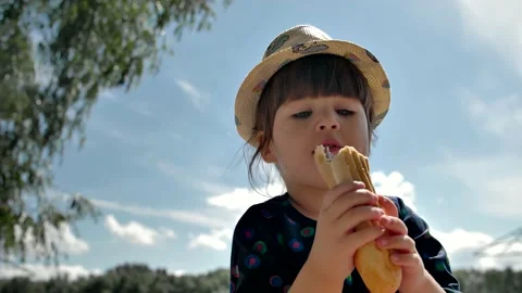 Funny child eats fast food and licks his lips. Stock Footage 201432491
