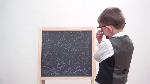Funny child focus on chalk board with math scribble, exhausted student, heavy   Stock Footage 77493644