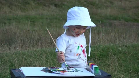 Funny child with stained face, hands painting in nature 4k Stock Footage 46212682