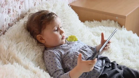 Funny child with a tablet in his hands watching cartoons on the Internet. Stock Footage 73918339