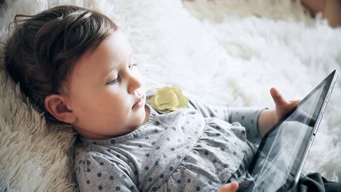 Funny child with a tablet in his hands watching cartoons on the Internet. Stock Footage 73918415