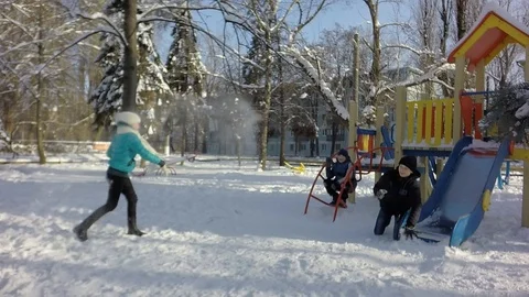 Funny children rush into each other with snow. Slow motion Stockbeeldmateriaal 87543417