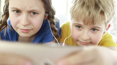 Funny children using Mobile Phone. Boy and girl in smartphone headphones.  Stock Footage 78071258