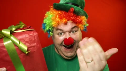 Funny clown and gift. Red background. Stock Footage 309503390