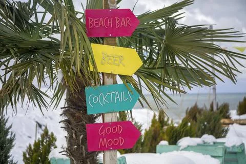 Funny colorful pointer to a beach bar on a snowy tropical beach Stockfoto's