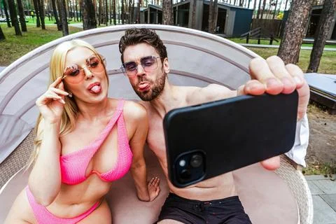 Funny couple posing at camera while making selfie on the smartphone while Foto stock