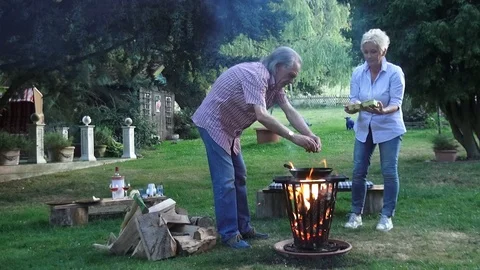 A funny couple preparing the fried eggs over the campfire in the fire basket Vídeo Stock 92445948