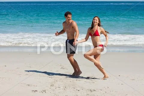 Funny Couple Running On The Beach