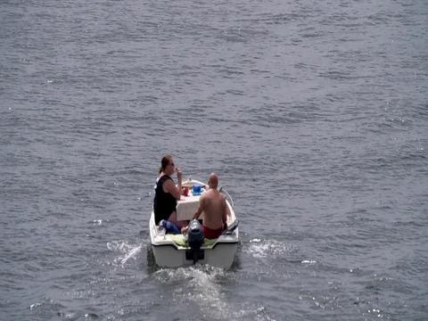Funny couple sailing small shaky boat on river, 4K Stock Footage 76538928
