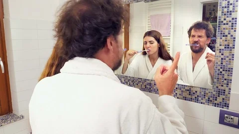 Funny couple singing and dancing while washing teeth in bathroom Stock Footage